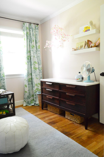 After Photo Of Nursery With DIY Changing Table And Floral Curtains