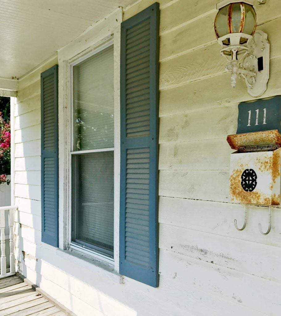 Before Detail of Font Porch With Dirty Siding And Blue Shutters