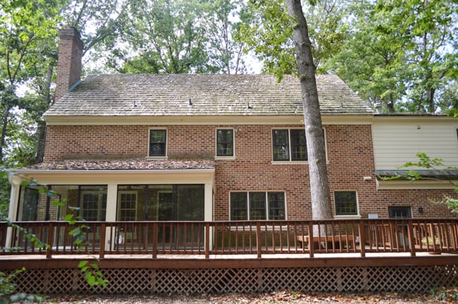Before View Of Back Of Brick Colonial House With Large Deck
