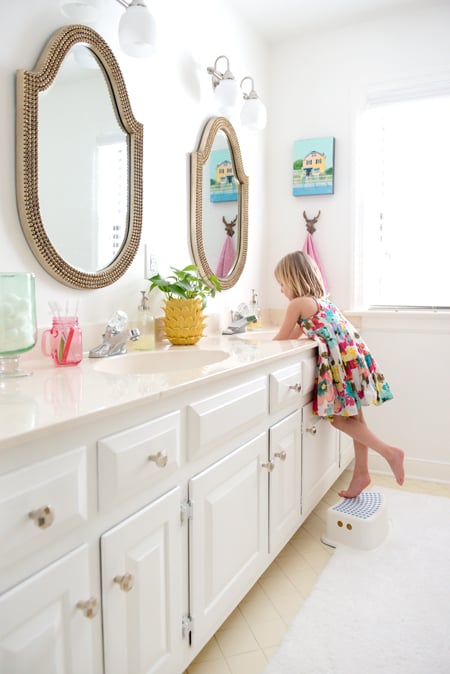 Mid Point Of Hall Bathroom With White Vanity And Walls And Decorative Beaded Mirrors