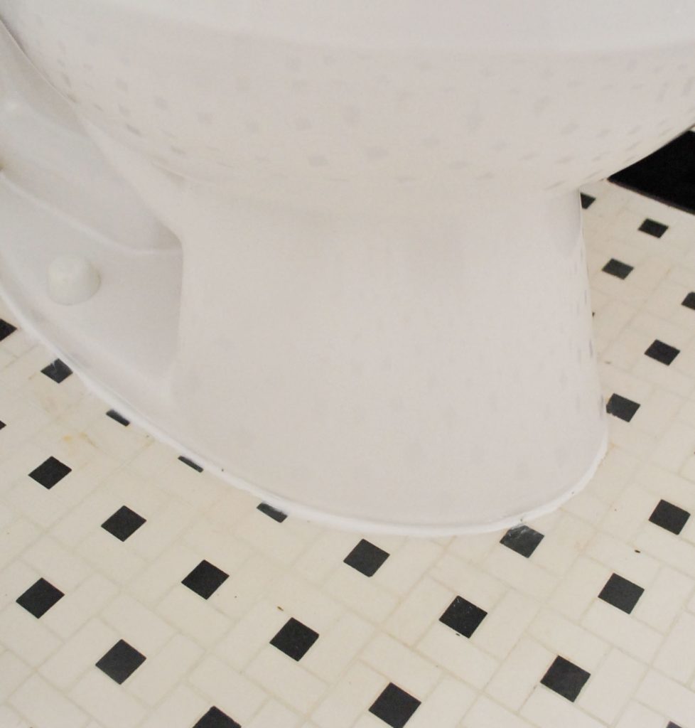 Line Of White Caulk Around Base Of Installed Toilet