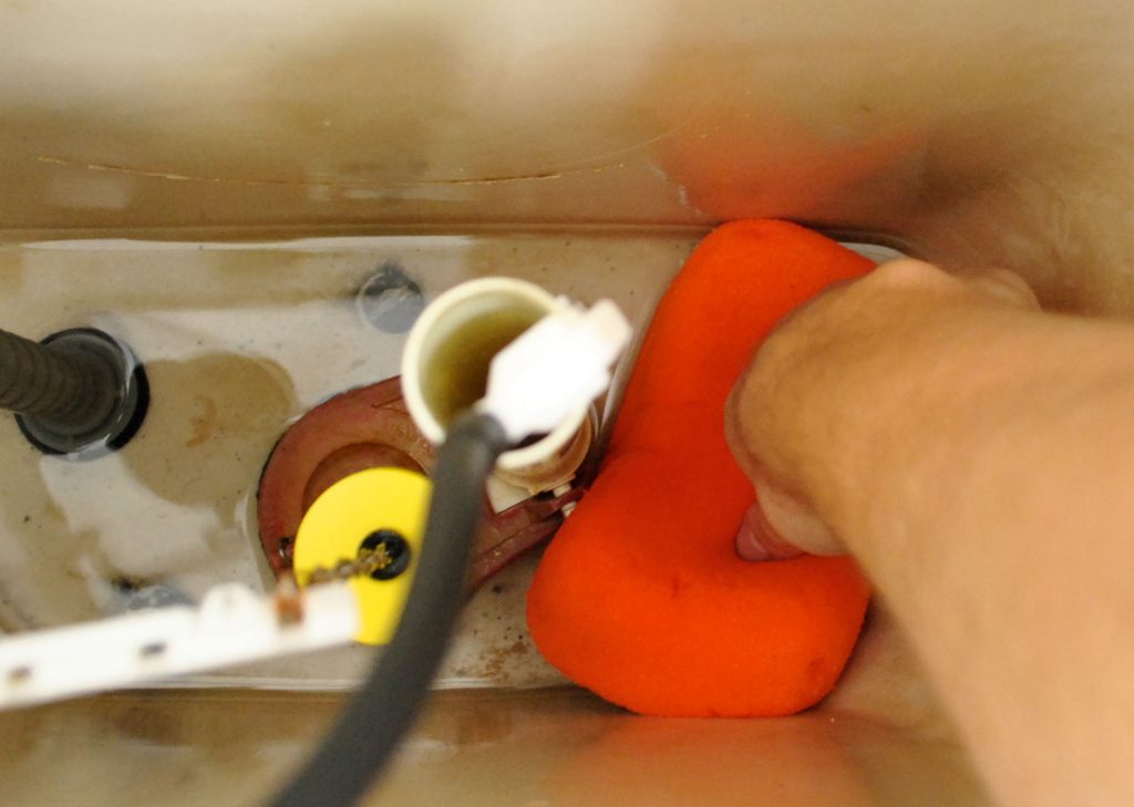 Sponge Soaking Up Water In Toilet Bowl Tank