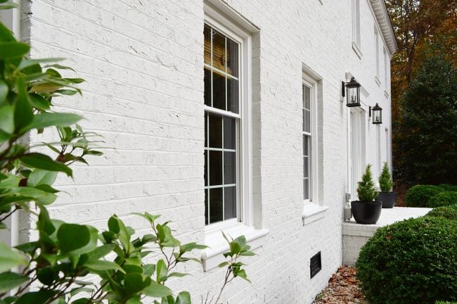 Close Up Photo Of White Painted Brick Home From Side