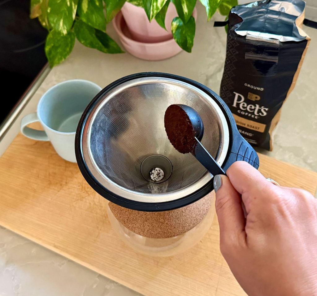Adding One Scoop of Ground Coffee Into Pour Over Coffee Maker