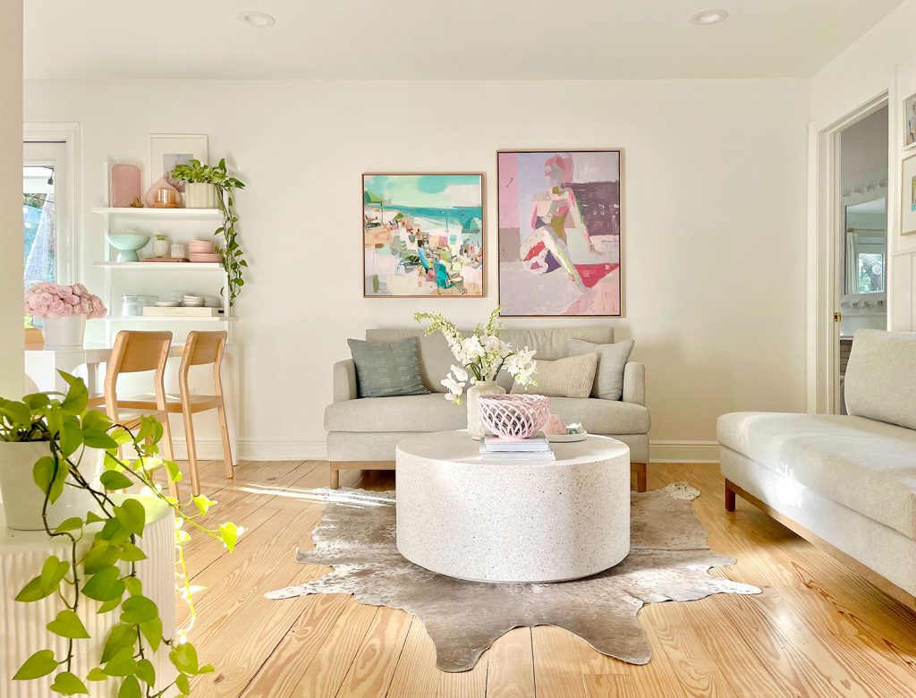 Seating Area With Two Gray Loveseat Sofas And Bright Abstract Paintings