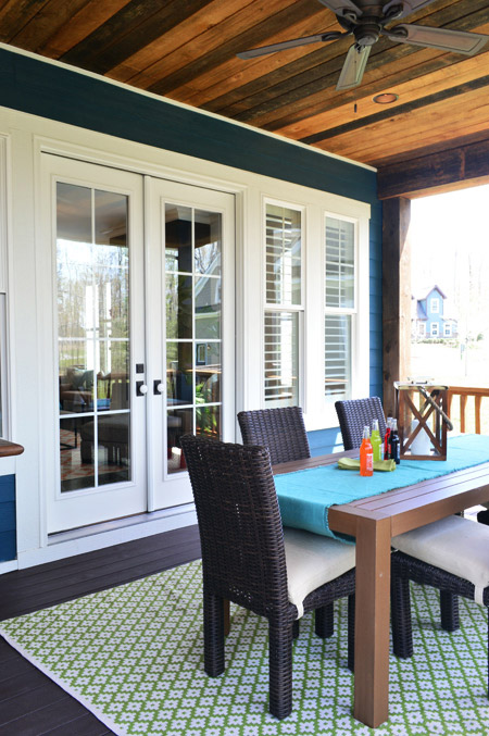 Covered Porch Area With Rustic Wood Ceiling And Outdoor Dining Table