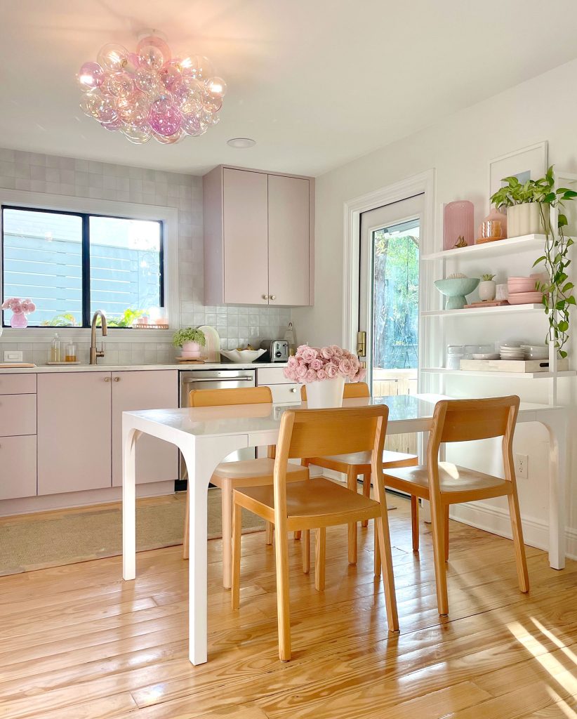 Modern White Breakfast Table In Kitchen With Mauve Cabinets And Bubble Glass Light Fixture