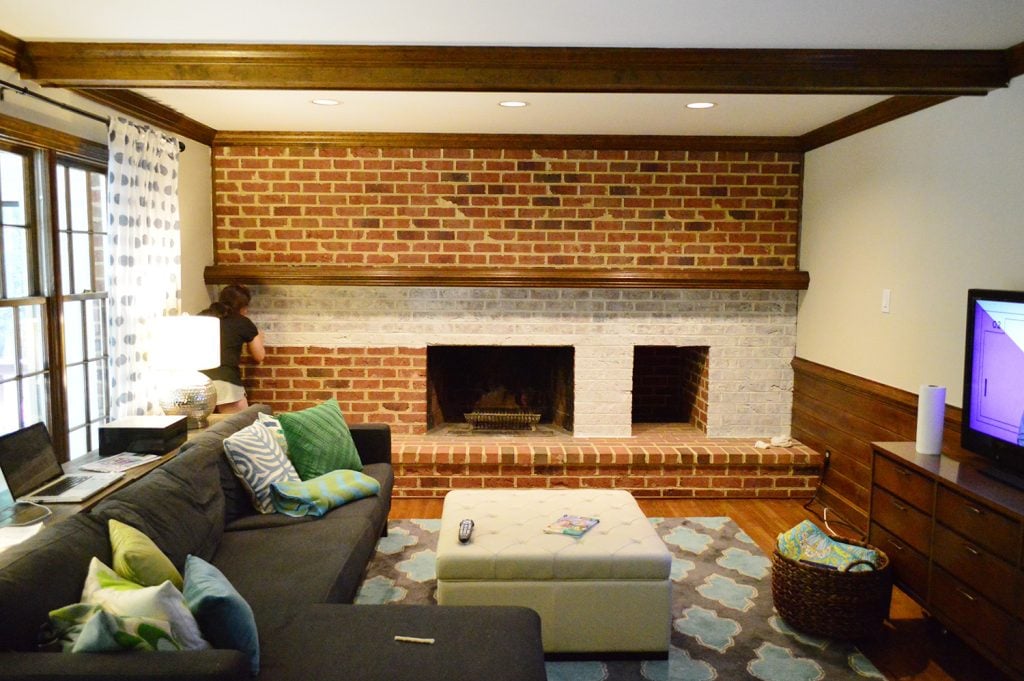whitewash brick technique being applied to living room fireplace wall made of brick